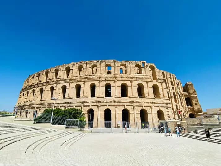 La façade à arcades de l'amphithéâtre romain d'El Jem sous un ciel bleu